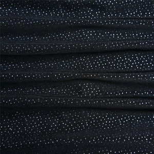 Close-up of black fabric texture with silver glitter details and star-like shimmering effect