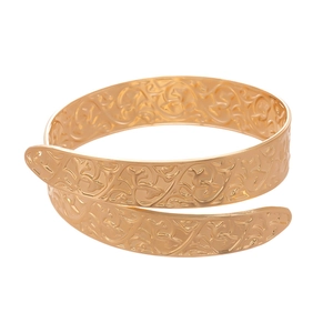 Golden wrap-around cuff bracelet with vintage floral relief patterns on white background