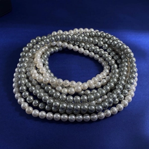 Elegant multi-layer white and grey pearl necklace set on luxury dark blue velvet