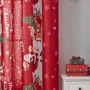 Detail of red Christmas curtain fabric with Santa and Merry Christmas festive prints