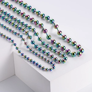 Close-up of rainbow electroplated stainless steel ball chain necklaces on white pedestals