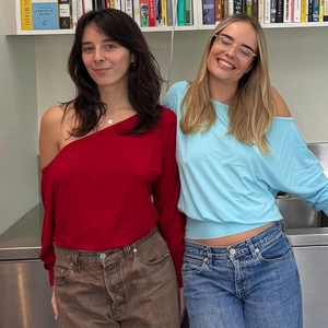 Detail of red and light blue off-shoulder long sleeve tops worn by models in a casual setting