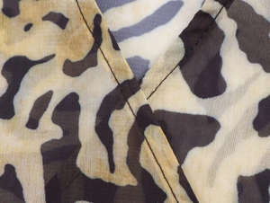 Macro shot of V-neck stitching detail on leopard print chiffon fabric with clear seams