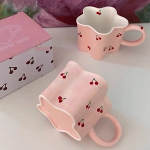 Detail of pink ceramic cherry mugs with petal-shaped rim and matching gift box set