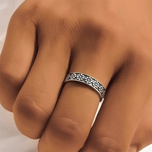 Macro shot of vintage S925 silver ring featuring embossed floral patterns and oxidized details