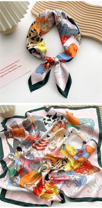 Detailed view of pink silk scarf with cartoon cat print and green borders