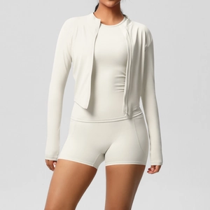 Détail d'un ensemble de yoga blanc cassé avec veste zippée, débardeur et short de sport