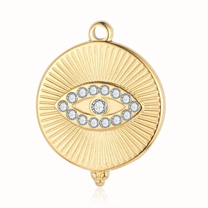 Detailed view of a golden evil eye pendant with embedded crystals and sunburst engravings