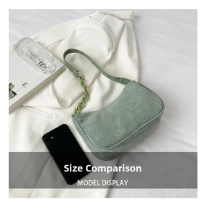 Detail of mint green corduroy hobo bag with stylish resin chain and textured finish