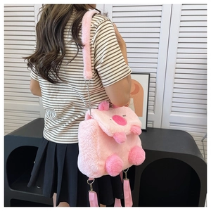 Detailed view of plush pink cartoon pig bag with ears and limbs worn by a model