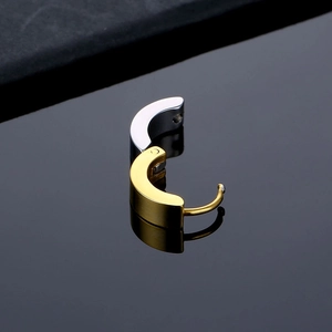Macro shot of two-tone stainless steel huggie earrings featuring high-polish finish