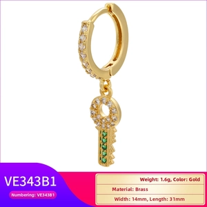 Macro detail of gold key earring with green zircon pavé on polished brass finish