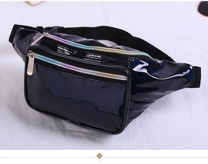 Detail of black glossy patent leather fanny pack featuring iridescent rainbow zippers