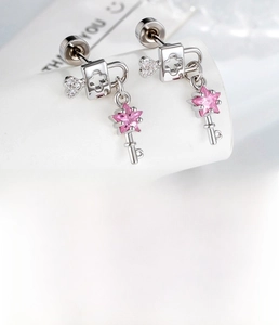 Close-up of heart lock and star key earrings with zircon wings and pink crystal pendants