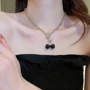 Detailed view of a silver-toned chunky chain necklace with black cherry pendant and OT buckle