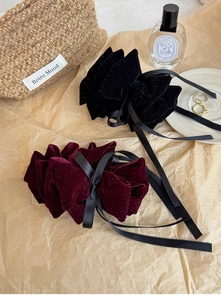 Detail of vintage velvet flower hair clips with glitter texture and black satin ribbons