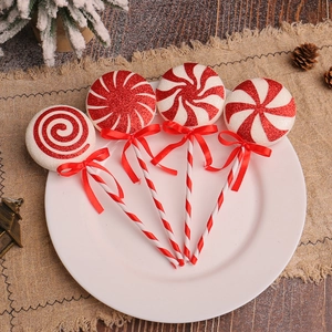 Set of four red and white glitter Christmas lollipop ornaments on festive rustic background