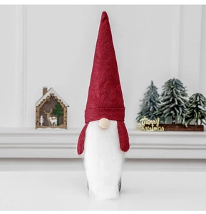 Close-up of Nordic Christmas gnome decoration with red felt hat and white faux fur beard