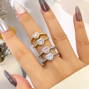 Close-up of heart-shaped rings with pink and clear cubic zirconia on a model's hand