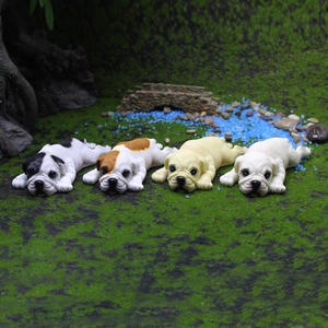 Lot de quatre figurines de chiots bouledogues anglais en résine dans un décor de jardin