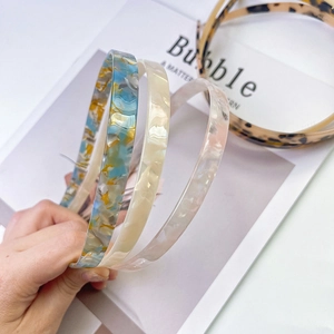 Three acetate marble pattern slim headbands in blue, beige, and pink colors for women