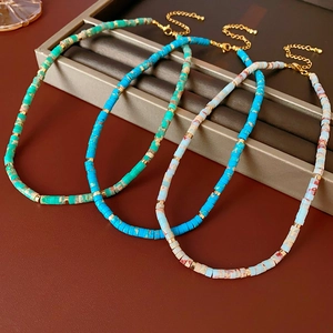 Detailed shot of bohemian beaded necklaces with stone discs and golden lobster clasps