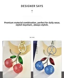 Close-up of glitter cherry keychains in red and blue with metallic leaf details