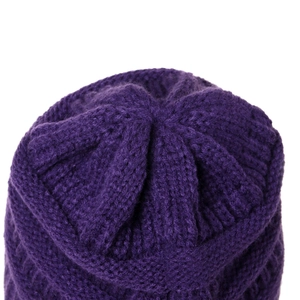 Detail of deep purple knit beanie showing thick wool yarn texture and top stitching