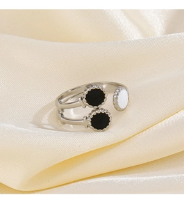 Detail view of silver enamel open ring with beaded trim on elegant beige satin fabric