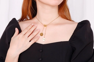 Detail view of golden Y-shaped necklace with heart charm and family silhouette pendants