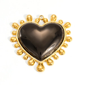 Detailed view of heart-shaped pendant with black gemstone and 18K gold-plated beaded frame