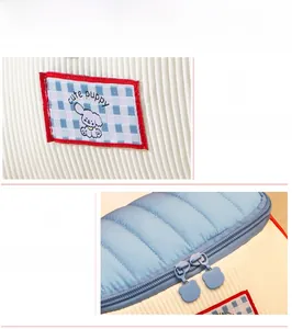 Detail of cute puppy house makeup bag with bear zipper pulls and corduroy fabric texture