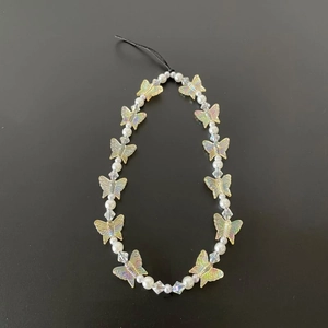 Detail of colorful transparent butterfly beads and white pearls on a phone wrist strap