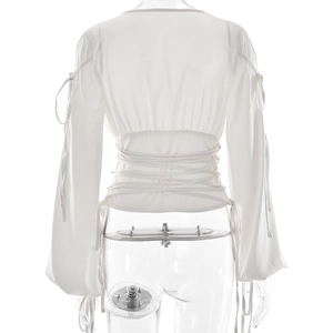 Détail du haut en satin blanc avec laçage, manches évasées et dos nu élégant
