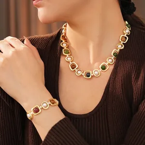 Vintage gold geometric jewelry set with pearls and colorful gemstones on a model