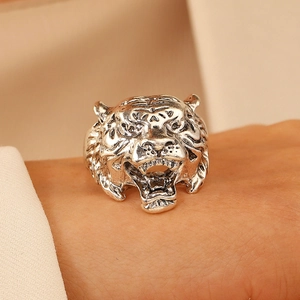 Gros plan sur une bague tête de tigre argentée vintage avec texture 3D et motif rugissant