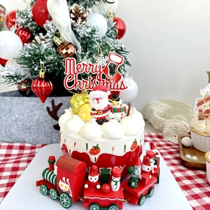 Detail of Merry Christmas acrylic cake topper with festive wooden train and Santa Claus decor