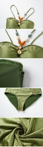 Close-up of olive green swimwear fabric with V-shaped texture and colorful bead details