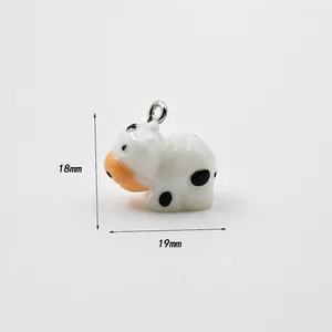 Detail view of a 18mm x 19mm cow-shaped acrylic pendant with metal hook for DIY crafts