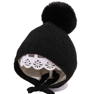 Warme schwarze Strickmütze für Babys mit Kunstfellbommel und Ohrenklappen für Kleinkinder