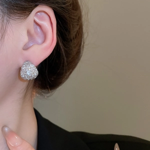 Close-up of elegant silver teardrop earrings with pavé zircons on a model's ear
