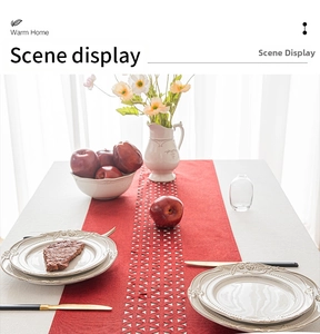 Detail of red table runner featuring geometric cutout edges on a white dining table