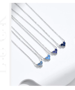 Macro shot of s925 silver necklaces featuring gradient blue heart shaped crystal pendants
