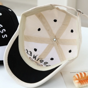 Detail of baby baseball cap interior showing Happiness embroidery and polka dot lining