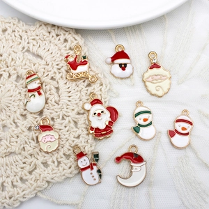 Detail of Christmas enamel alloy charms featuring Santa Claus and snowman on lace background