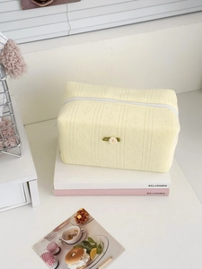 Close-up of quilted cotton cosmetic bag featuring a white rose and zip closure