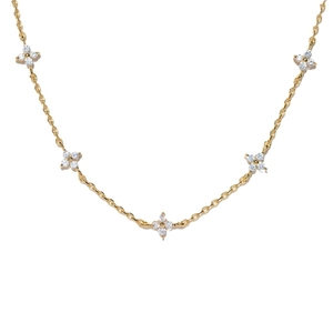 Collana a fiore dorata minimalista con micro-pave di zirconi su sfondo bianco puro
