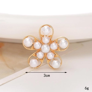 Macro shot of 3cm white pearl and gold metal five-petal flower charm for shoes
