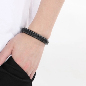 Close-up of men's double-layer black leather bracelet with white stitching and magnetic clasp