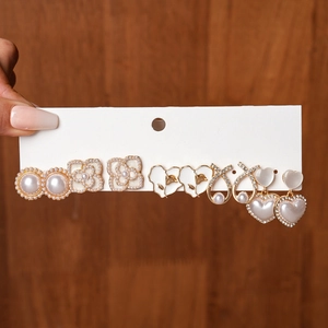 Detailed set of six pairs of gold earrings with faux pearls and floral enamel charms